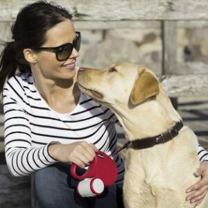 אישה מחבקת כלב עם רצועה של פלקסי